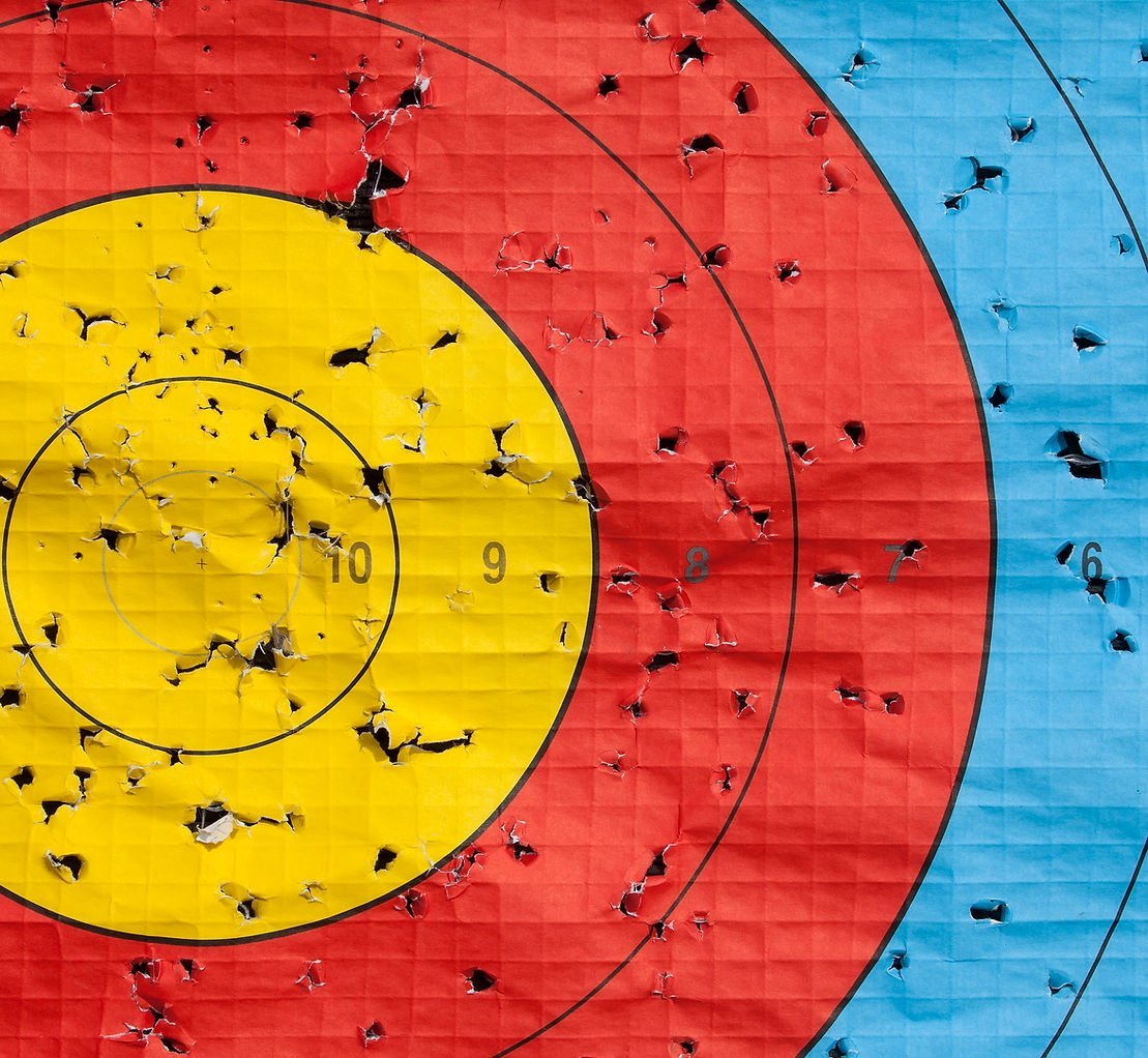 Archery target with arrow strikes clustered on the bullseye